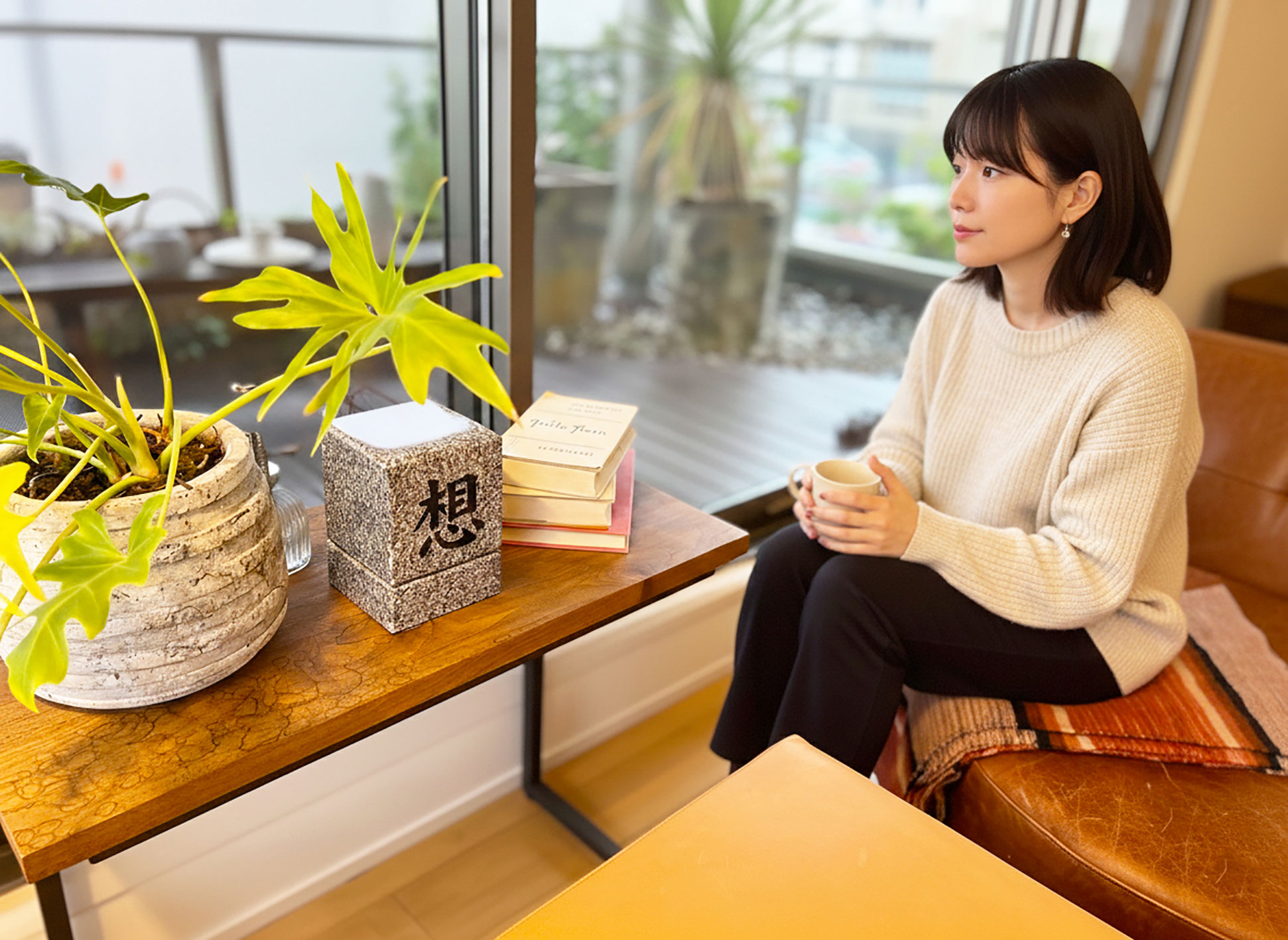 卓上墓の前で静かに手を合わせる女性