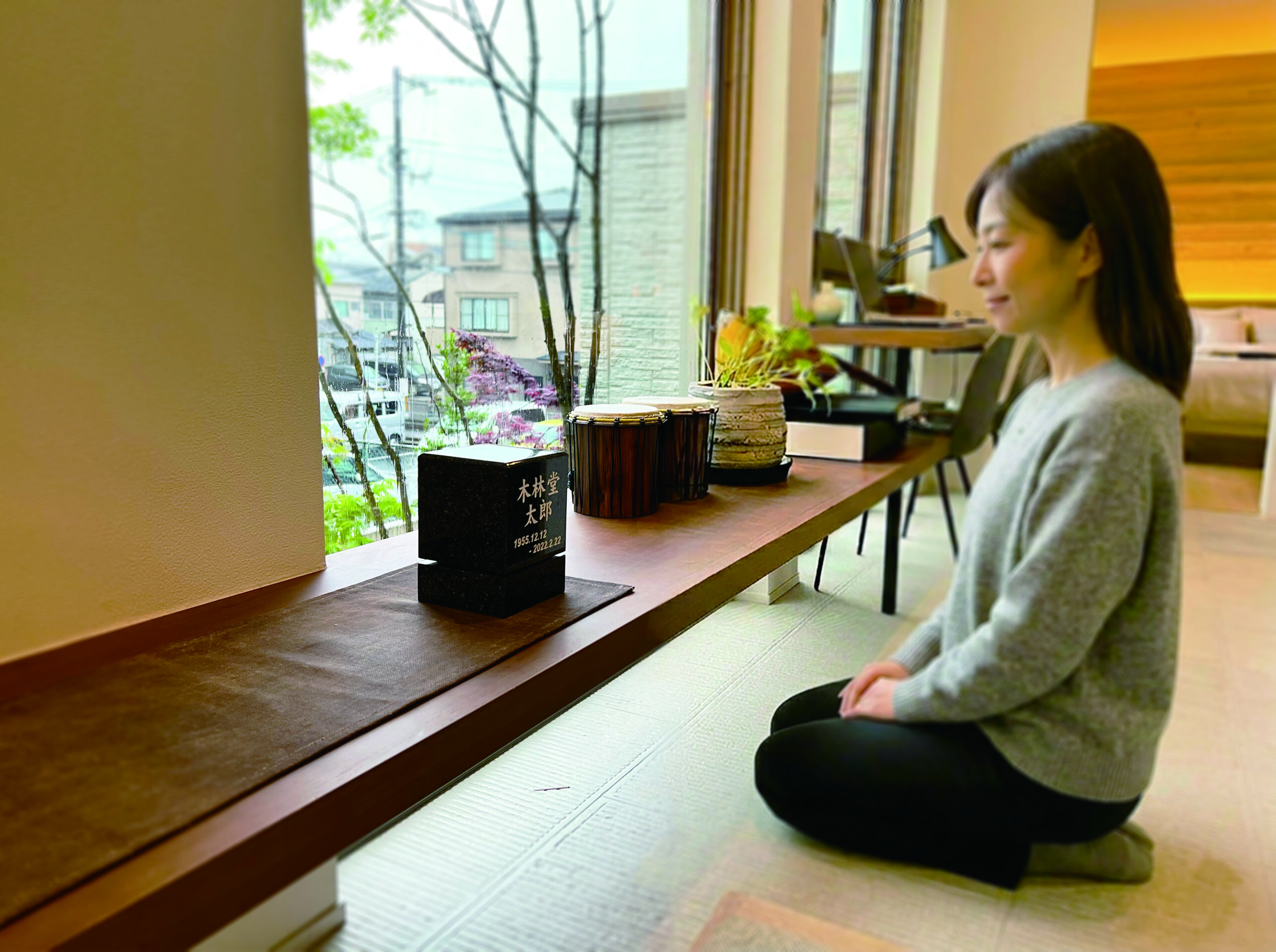 卓上墓の前に座る女性