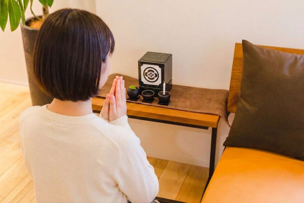 祖父と孫が卓上墓の前で語らう