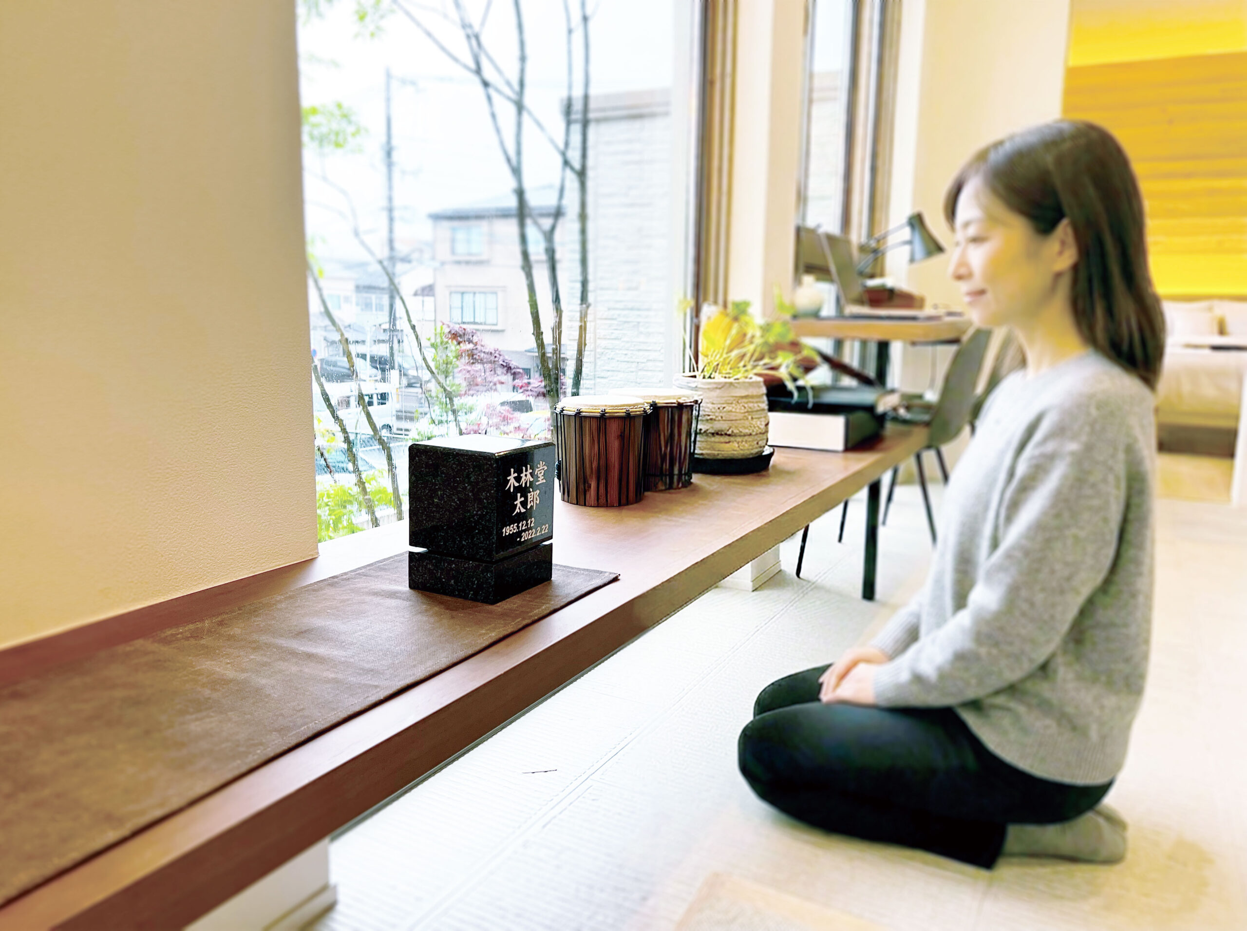 卓上墓の前に座る女性
